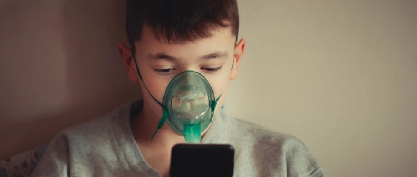 Boy using positive expiratory pressure therapy
