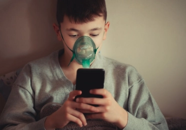 Boy using positive expiratory pressure therapy